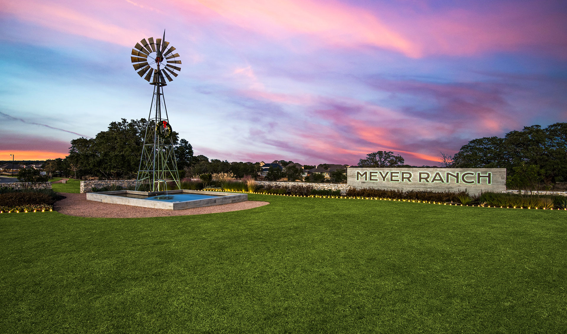 Meyer ranch entry gate with windmill at sunset