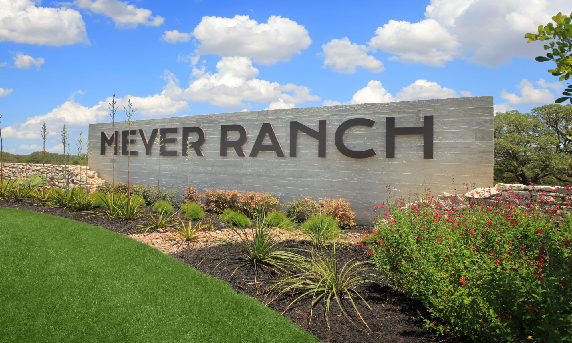 Meyer Ranch community entrance sign against blue sky filled with clouds
