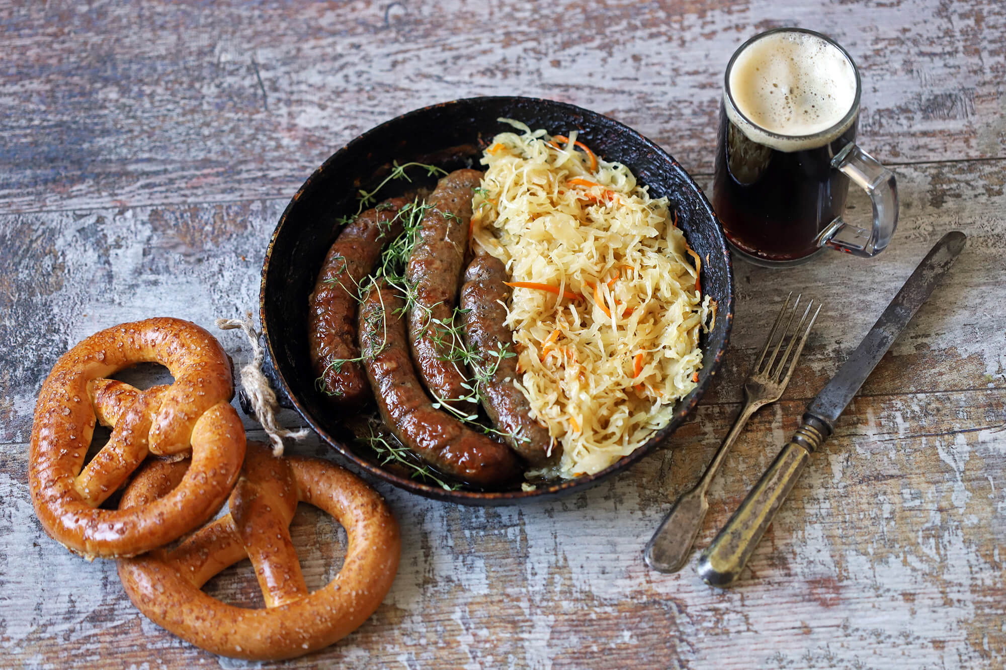 Traditional German meal of sausage and sauerkraut with pretzels and beer on the side